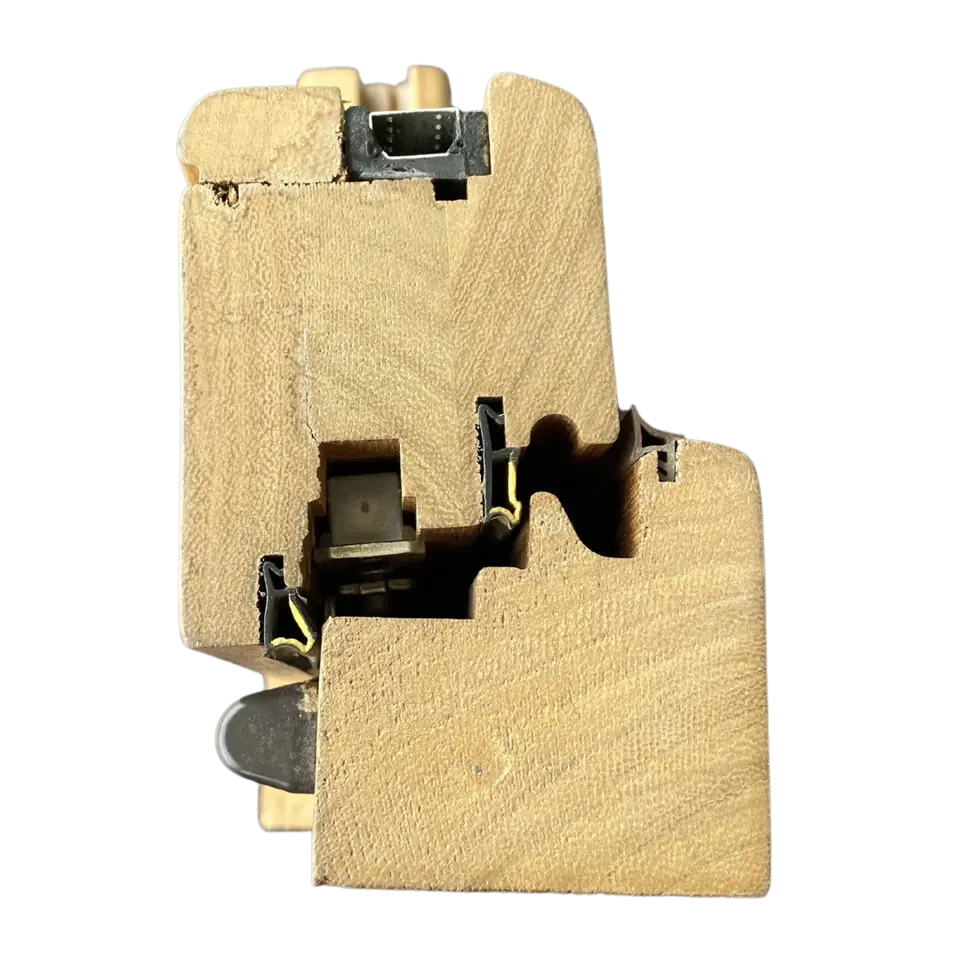 Sección de un perfil de ventana de madera con herrajes y juntas